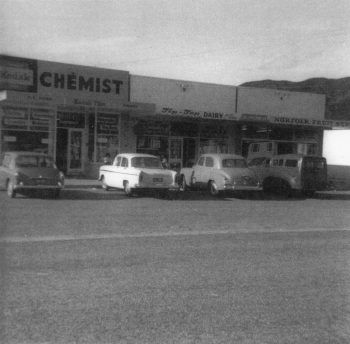 2nd block of shops, Norfolk Street, (Chemist, Diary, Fruit shop - Upper Fitzherbert Rd end) Wainuiomata - c1966 - WHMS: B546, ex Jack Logan