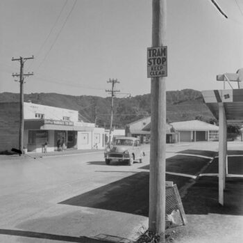 19 Apr 1960 Wainuiomata street scene with a tramstop sign and Bradbrury's Fish Supply shop, Lower Hutt, Wellington Region. Dominion Post (Newspaper): Photographic negatives and prints of the Evening Post and Dominion newspapers. Ref: EP/1960/1384-F. Alexander Turnbull Library, Wellington, New Zealand. https://natlib.govt.nz/records/30660699