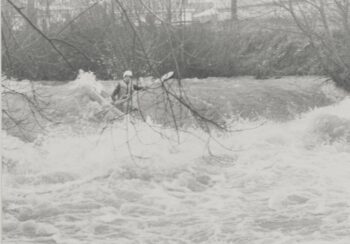Kerry Richardson in his kayak navigating the rapids in a flooded Wainuiomata River - 1985 - CC BY-NC-ND 3.0